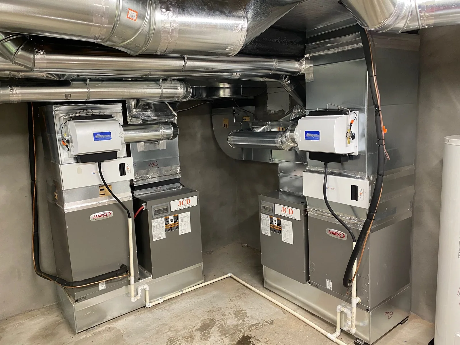 Two Lennox furnaces with whole-house humidifiers in a basement mechanical room